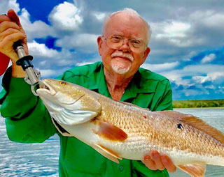 Man holding a large fish after going on a Whiskey Bayou charter