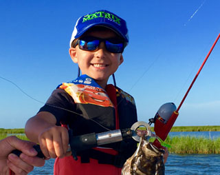 catching-fish-06 Small kid with a fishing rod and a smaller fish he caught