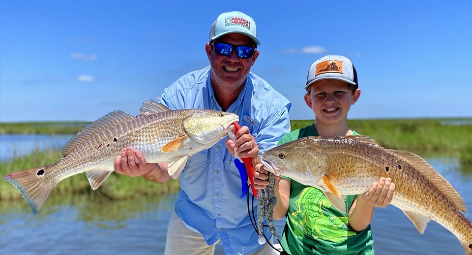 two people after fishing charter with large fish