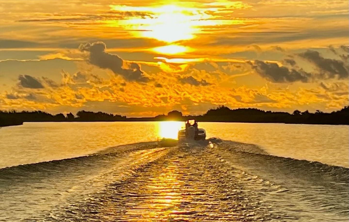 Boat driving into the sunrise 