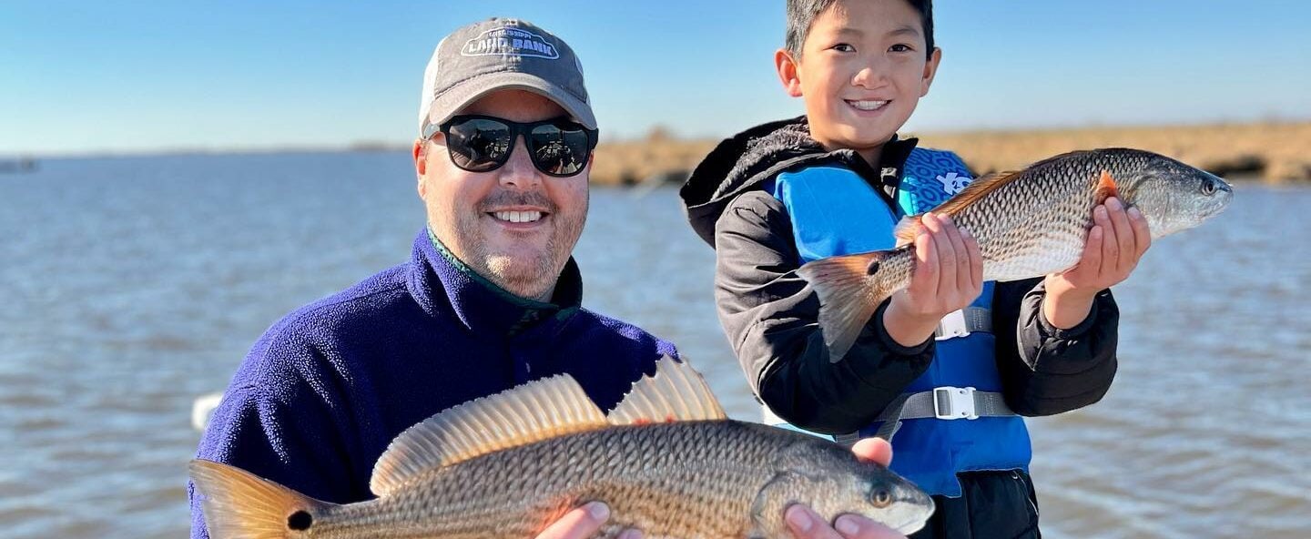 Family-Friendly Fishing Tips | Whiskey Bayou Charters | Delacroix, LA Father and son holding up the fish they caught in Delacroix, LA.
