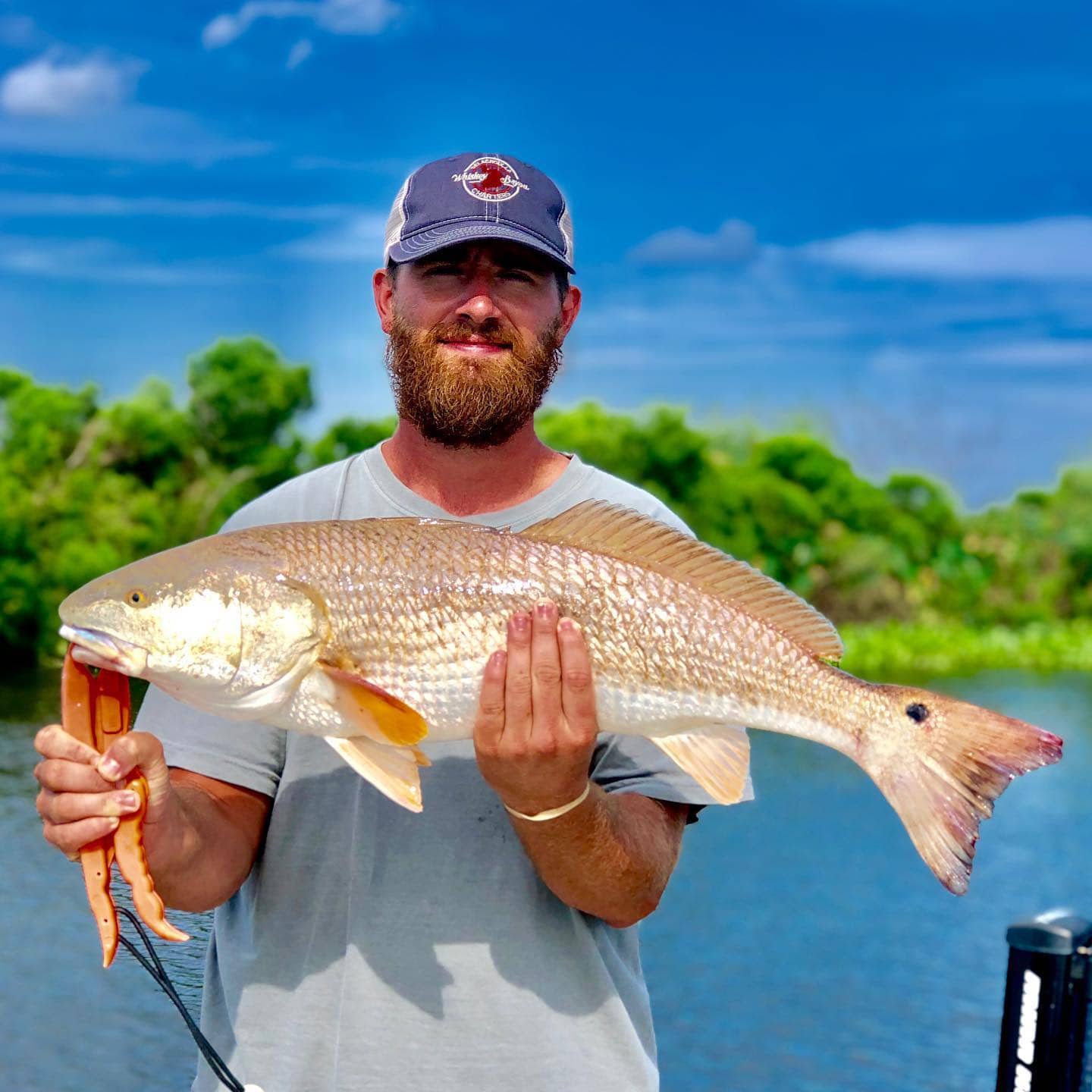 Man holding up a redfish on a fishing charter.