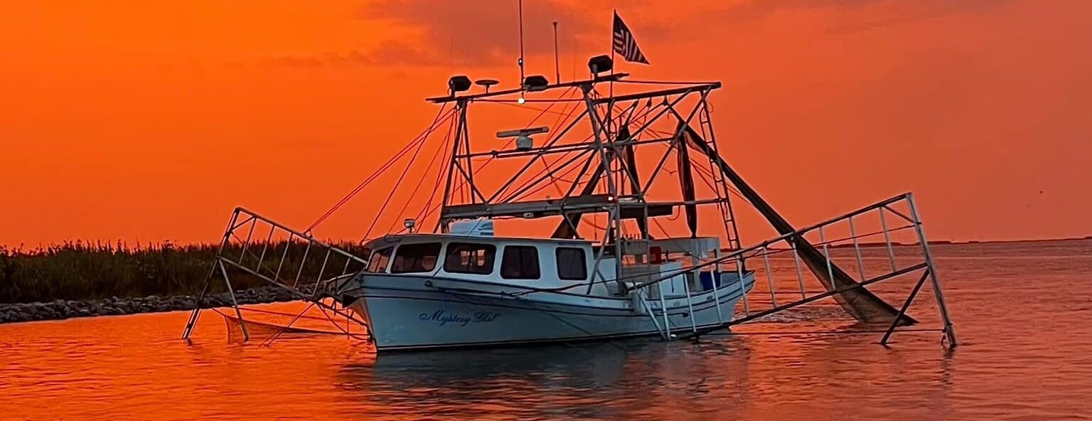 White Boat Red World Image of a white fishing boat on the water. Both the sky and water are painted a orange red by the sunset.