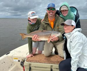 A family of four posing for a photo with their catch.