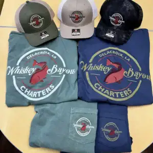 Photo of Whiskey Bayou brand shirts and trucker hats.