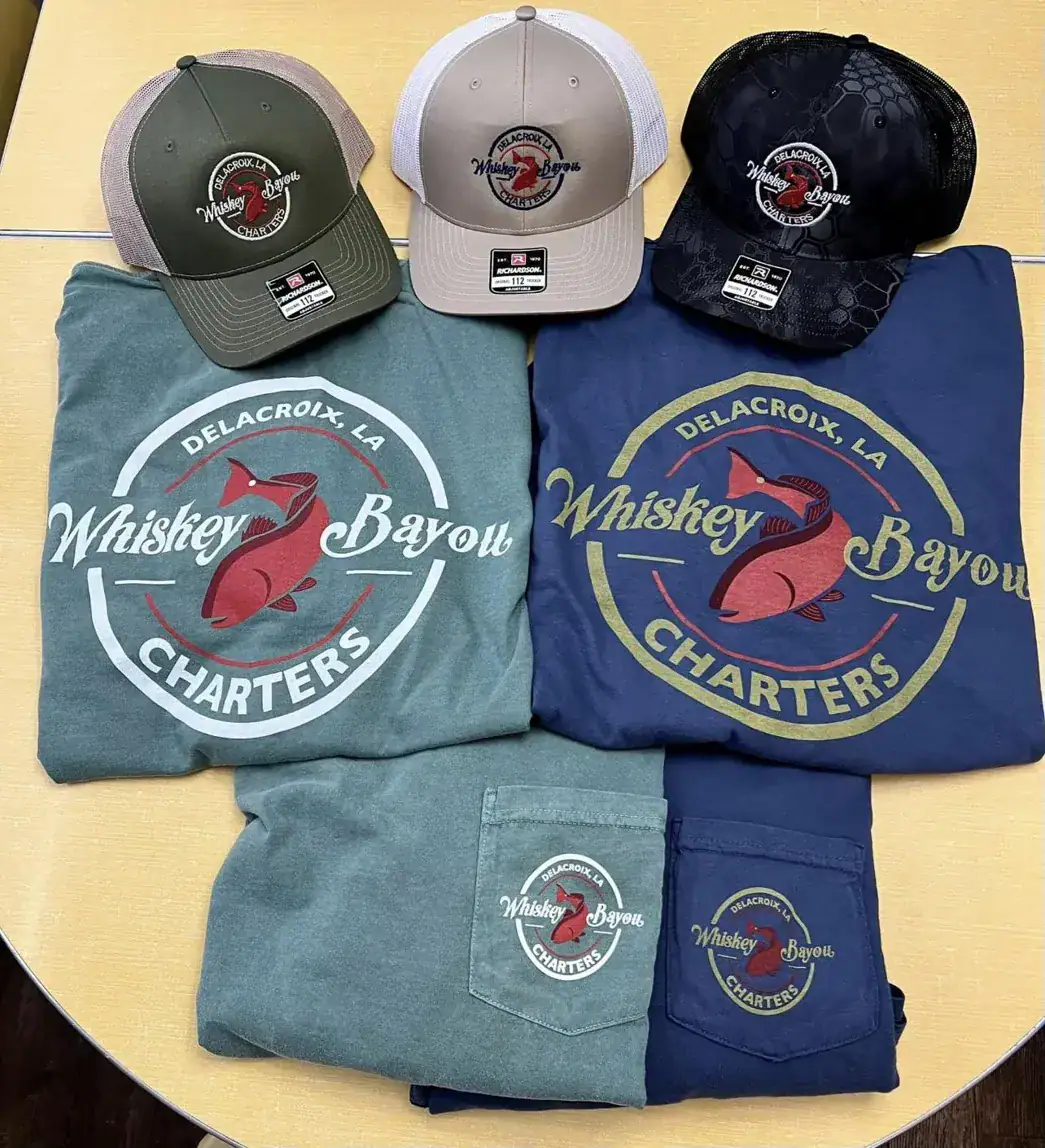 Photo of Whiskey Bayou brand shirts and trucker hats.