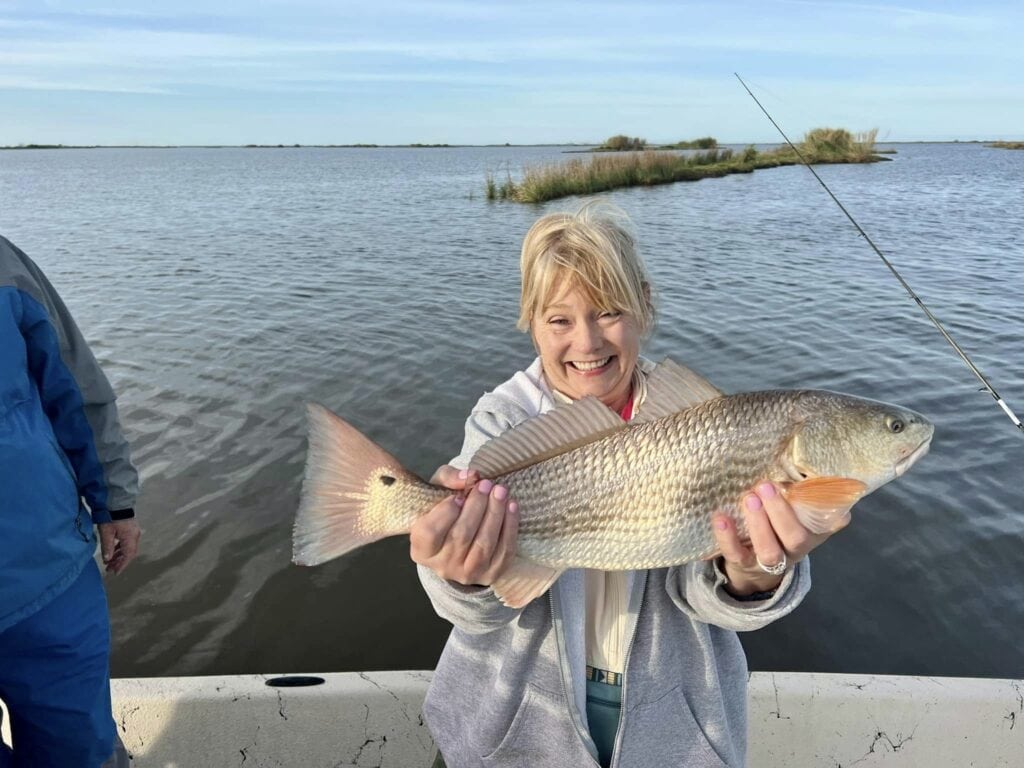 Happy lady holding up her catch for the camera